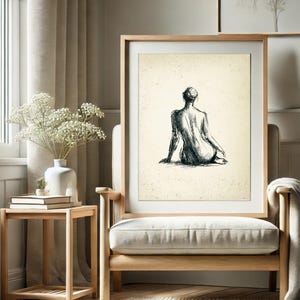 May include: A black and white line drawing of a person sitting with their back to the viewer. The drawing is on a cream-colored background and framed in a light wood frame.