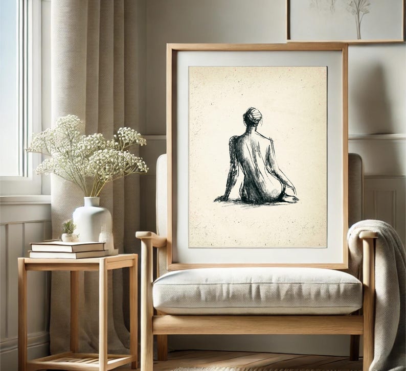 May include: A black and white line drawing of a person sitting with their back to the viewer. The drawing is on a cream-colored background and framed in a light wood frame.