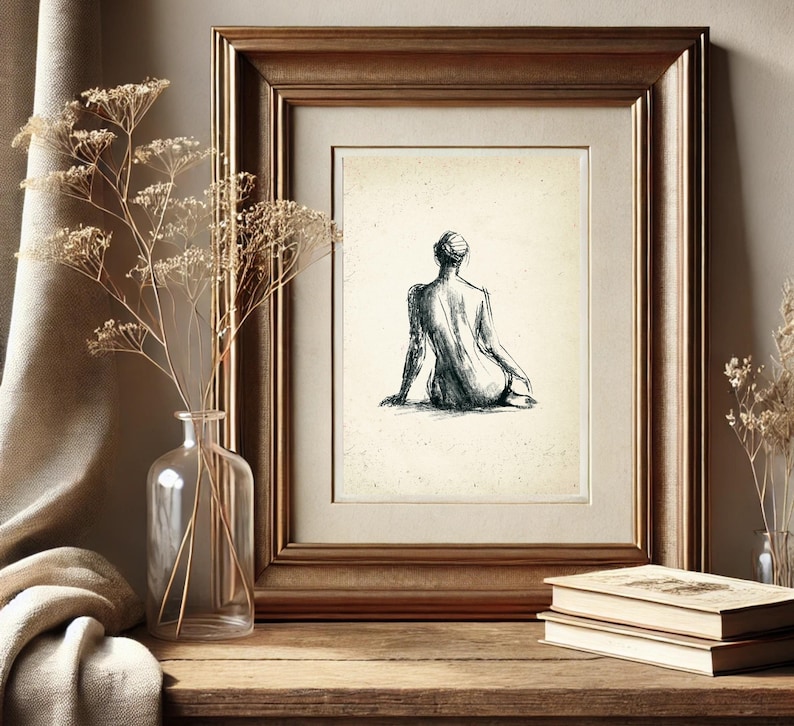 May include: A black and white line drawing of a person sitting with their back to the viewer. The drawing is framed in a gold frame and is hanging on a wall.