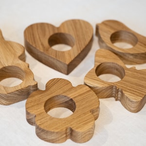 Peut inclure: Cinq supports à œufs en bois en forme de cœur, de fleur, de papillon, d'oiseau et de lapin. Les supports sont tous en bois naturel et ont un aspect rustique.