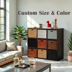 May include: A black storage cabinet with nine cubbies, each containing a woven basket in various colors: natural, white, gray, black, and shades of orange. The text "Custom Size & Color" is displayed above the cabinet. Decorative items sit on top.