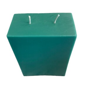 May include: A teal green pillar candle with two wicks.