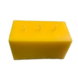 May include: A rectangular yellow candle with three wicks.
