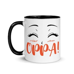 May include: White ceramic coffee mug with a black rim and handle. The mug features a cartoon anime-style face with closed eyes and the text "OPPA!" in orange.