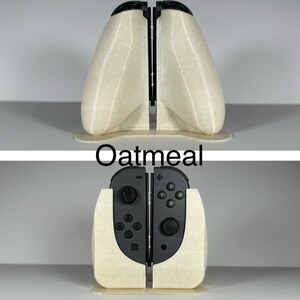May include: A beige 3D printed stand for a Nintendo Switch console. The stand is designed to hold the console in a vertical position. The stand is labelled "Oatmeal".