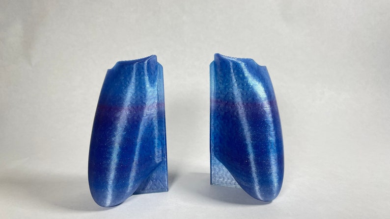 May include: Two blue and white striped 3D printed controller grips.
