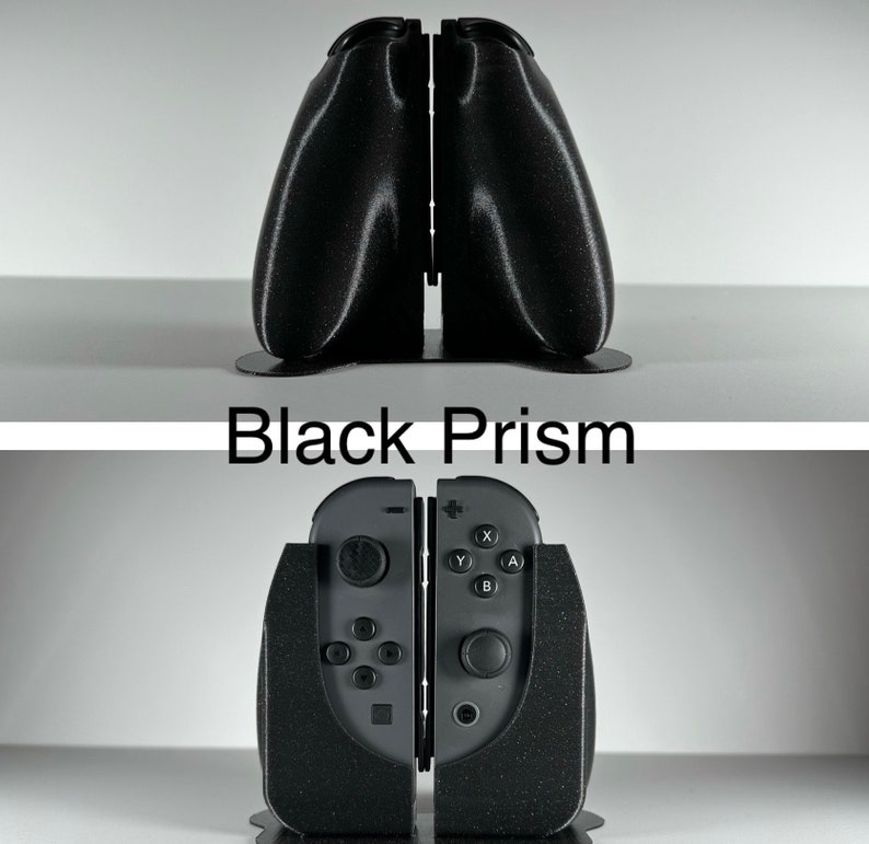 May include: A black, textured, 3D printed stand for a Nintendo Switch console. The stand is shaped like a prism and has a slot for the console to sit in. The text "Black Prism" is printed on the stand.