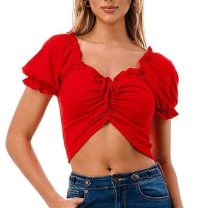 May include: A red cropped top with a sweetheart neckline and short puff sleeves. The top has a drawstring detail at the center front.