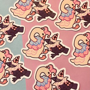 May include: A collection of stickers featuring whimsical illustrations of a swan and a crow, both adorned in jester attire. The swan is depicted in cream, pink, and blue, while the crow is dark purple with a checkered hat. The stickers are scattered on a blue and pink background.