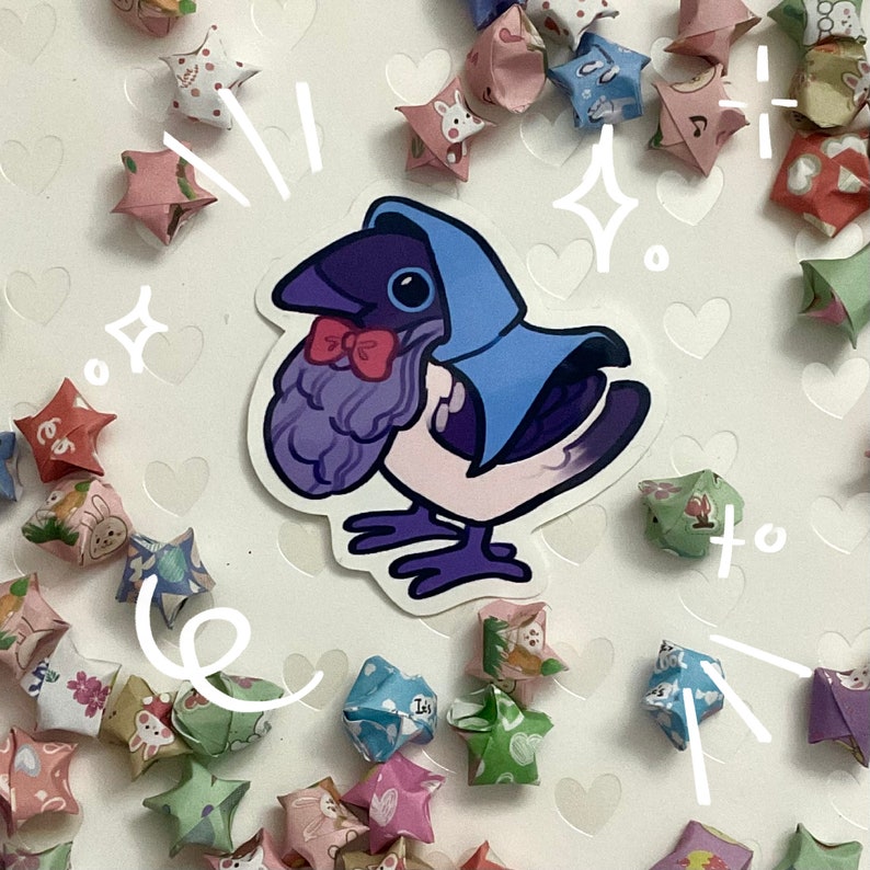 May include: A sticker featuring a cartoon bird with a purple head and blue hood, wearing a red bow tie. The bird has a white body and purple feet. The sticker is surrounded by colorful origami stars.