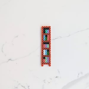 May include: A vertical beaded design with a red frame and colourful beads. The beads are arranged in a pattern of rows and columns.