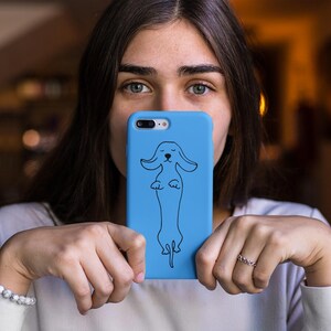 May include: A blue phone case with a black outline of a dachshund dog.