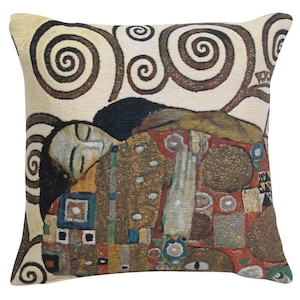 May include: A decorative throw pillow featuring a tapestry-style reproduction of Gustav Klimt's "The Kiss" painting. The pillow has a beige background with brown swirling patterns and a colorful depiction of two figures embracing.