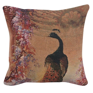 May include: A decorative throw pillow with a tapestry-style design featuring a peacock standing in front of a floral background. The peacock is black and green with a long neck and tail feathers. The background is a muted brown with pink and purple flowers.