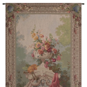 May include: A tapestry with a floral motif. The tapestry features a vase filled with pink, red, yellow, and white flowers. The vase is on a pedestal with a red cloth draped over it. The tapestry has a beige background with a floral border.