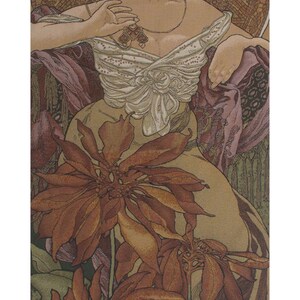May include: A vertical wall tapestry featuring an Art Nouveau illustration of a figure with dark hair adorned with cherries, wearing a white draped top, positioned behind large rust-colored poinsettia flowers, suspended from a black rod with gold tassels.