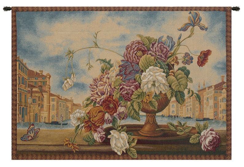 May include: A tapestry with a floral arrangement in a vase. The flowers are in shades of pink, purple, white, and red. The vase is brown and has a gold trim. The background is a cityscape with buildings and a canal. A butterfly is flying in the foreground.