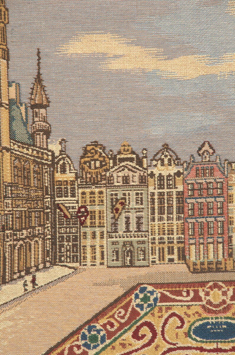May include: A tapestry depicting a cityscape with a variety of buildings, including a tall tower, in a muted color palette of browns, tans, and blues. The buildings have intricate details and windows. The tapestry has a textured surface and a woven design.