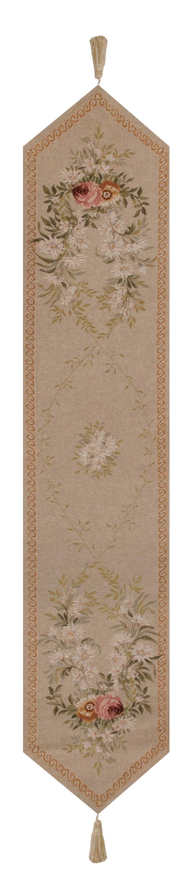 May include: A beige table runner with a floral pattern. The runner has a brown border with a repeating pattern and tassels on each end. The floral pattern is made up of white and pink flowers with green leaves.