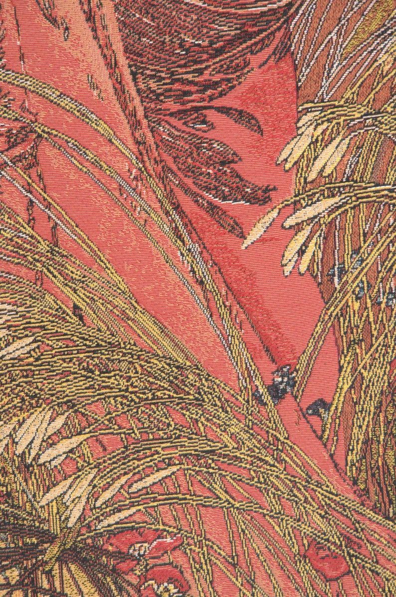 May include: A close-up of a red fabric with a woven pattern of yellow and brown leaves. The fabric has a textured surface and a vintage look.
