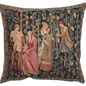 May include: A tapestry pillow featuring a medieval scene of four people harvesting grapes in a vineyard. The pillow has a black background with intricate details in shades of green, brown, red, and blue.