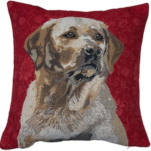 May include: A square cushion with a tapestry design of a Labrador Retriever dog. The dog is rendered in brown, tan, and white hues, set against a red backdrop with a floral pattern. The cushion has a zip closure. Measurements are not available.