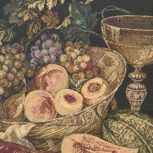 May include: A tapestry depicting a still life with a bowl of fruit, including grapes, peaches, and a melon. A gold goblet and a lobster are also featured in the composition.