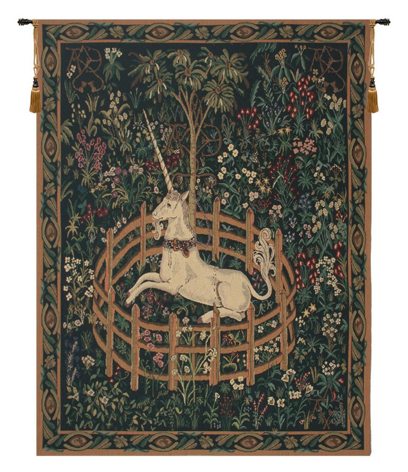 A woven tapestry featuring a resting unicorn. It is laying on the ground and encircled by a fence. The background is filled with flowers. Colors are predominantly green, with cream, pink, and red.