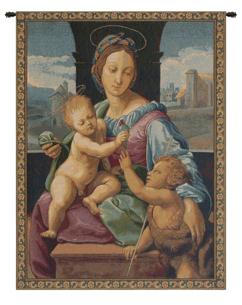 May include: A tapestry depicting a religious scene with a woman holding a baby in her lap. The woman is wearing a blue and pink dress and a blue head covering. The baby is reaching out to a small child standing on the right side of the image. The scene is set in a room with a window and a view of a city in the background. The tapestry has a gold and green border.