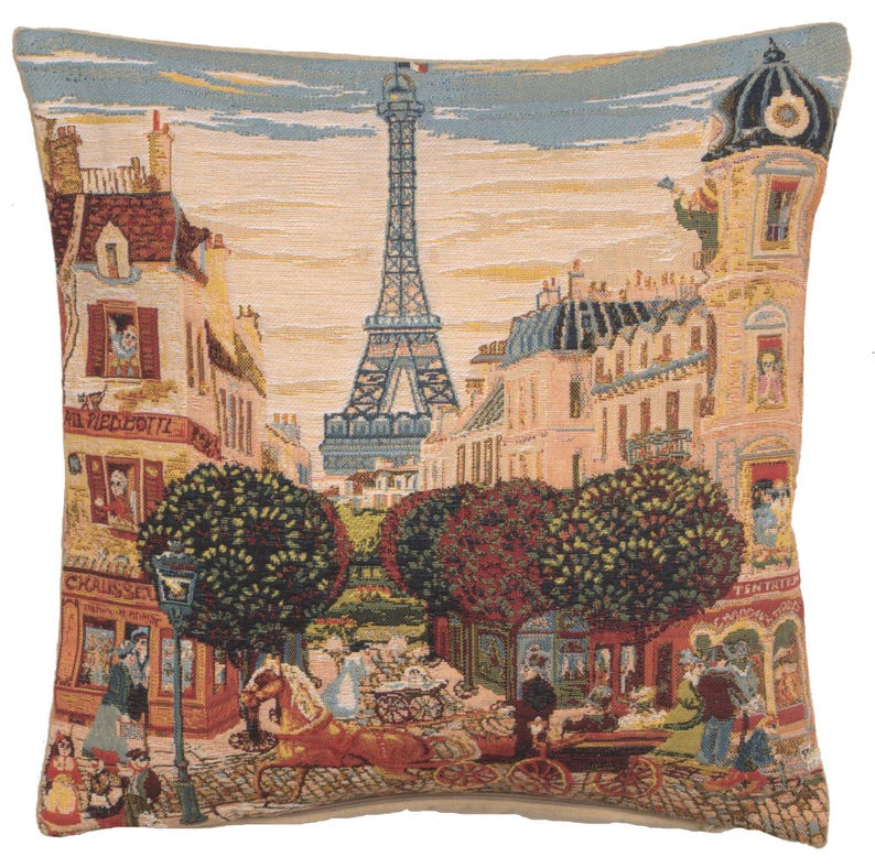 May include: A tapestry cushion featuring a colourful depiction of the Eiffel Tower in Paris, France. The cushion shows a street scene with shops, trees, and people walking by. The text 'La Medocette' is visible on one of the buildings.