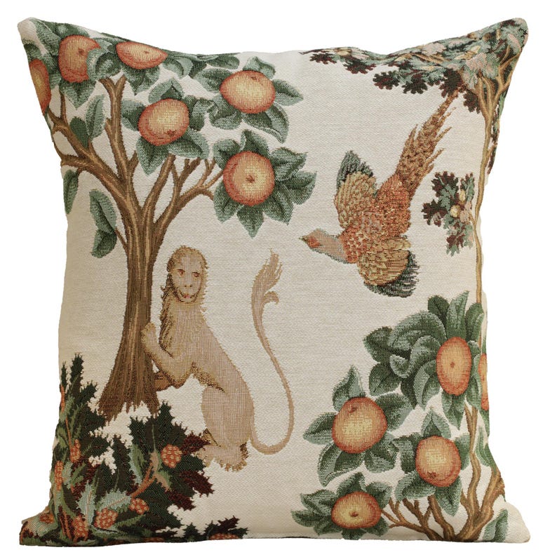 May include: A decorative throw pillow with a tapestry design featuring a monkey, a pheasant, and a tree with apples. The background is a cream color with green, brown, and orange accents.