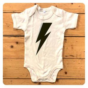 Natural coloured babygrow with black and sliver glitter lightning bolt