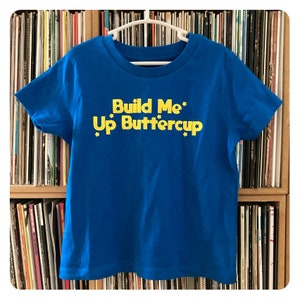 Build Me Up Buttercup royalblaues Kinder T-Shirt mit gelbem Flock Design
