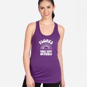 May include: Purple tank top with a white graphic that says "Floats Well With Others" and a stylized sun graphic.