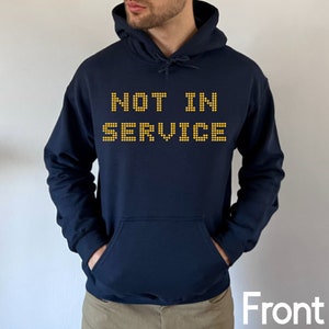 May include: A navy blue hoodie with a yellow graphic that reads "NOT IN SERVICE".