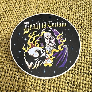 DEATH IS CERTAIN wizard necromancer holding a flaming skull vinyl sticker