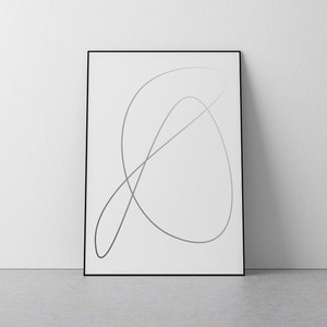 May include: A black framed print with a single, abstract line drawing in shades of gray on a white background.