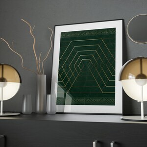 May include: Two modern table lamps with brown glass shades and white bases, a framed print with a green background and gold geometric design, and a vase with dried branches on a black shelf.