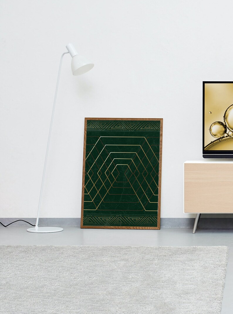 May include: A framed print with a geometric design featuring gold lines on a dark green background.