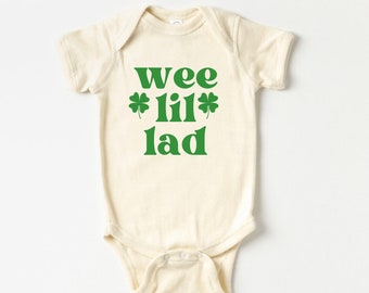 May include: A cream-colored baby onesie with a green shamrock design and the text "wee *lil* lad".