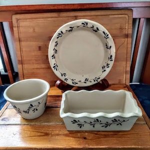 May include: Three ceramic dishes with a white background and a blue floral design. The dishes are on a wooden surface.