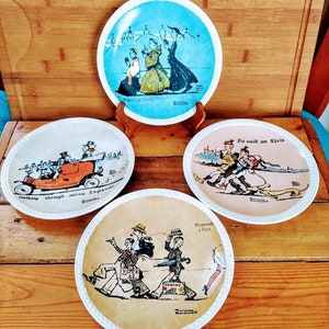 May include: Set of four vintage decorative plates with white rims and colorful illustrations. The plates depict scenes of people walking in different locations, including England, Paris, and the Rhine River. The plates have text on them, including "When in Rome", "Walking through merry England", "Promenade a Paris", and "Die walk am Rhein".