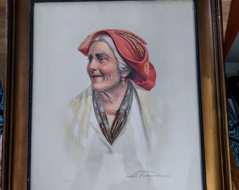 May include: A framed portrait of an elderly person wearing a red hat and a white blouse. The portrait has a gold frame and a signature in the bottom right corner. The person is smiling and wearing a scarf with green and red accents.