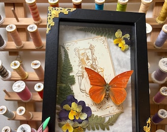 Orange albatross (Appias nero). Inramad insekt med tarotkort och blommor