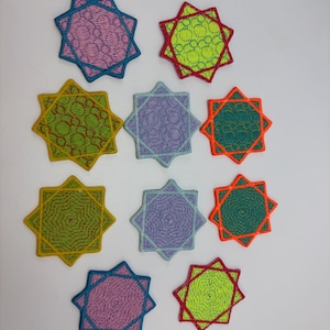 Puede incluir: Una colección de diez parches bordados en forma de estrella. Cada parche presenta una combinación de colores única, incluyendo rosa, verde, azul y naranja, con patrones intrincados. Los parches son adecuados para fines decorativos.