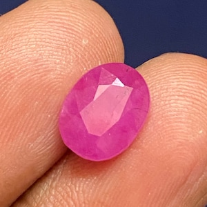 Könnte beinhalten: Ein lebhafter, ovaler Edelstein in Pink mit facettiertem Schliff.
