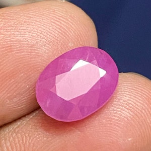 Può includere: Una gemma ovale di colore rosa vibrante con taglio sfaccettato.