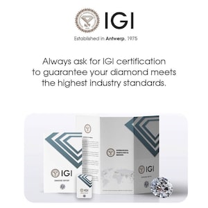May include: A white and gray diamond grading report with the IGI logo and the text "International Gemological Institute" and "Diamond Report". The report is folded in half and is sitting on a white surface. A small, clear diamond is sitting on a white surface next to the report.