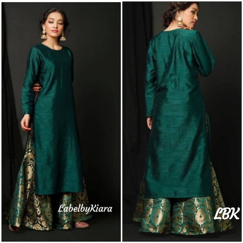 Op de afbeelding: Een lange, donkergroene kurta met lange mouwen en een ronde hals. De kurta wordt gecombineerd met een gouden en groene brokaat palazzo broek. De tekst "LabelbyKiara" is zichtbaar in de linkerbenedenhoek van de afbeelding.
