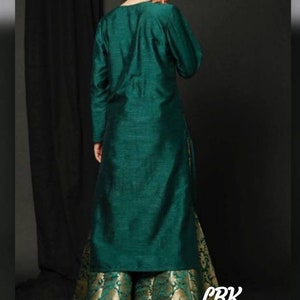 Op de afbeelding: Een lange, tealgroene kurta met lange mouwen en een bijpassende tealgroene palazzo broek met een gouden brokaatpatroon. De palazzo broek heeft een uitlopende silhouet. De outfit is in traditionele Indiase stijl.